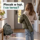 Przedpokój po szkole w dziennym świetle: plecak przy drzwiach, buty, dziecko od tyłu zdejmuje kurtkę